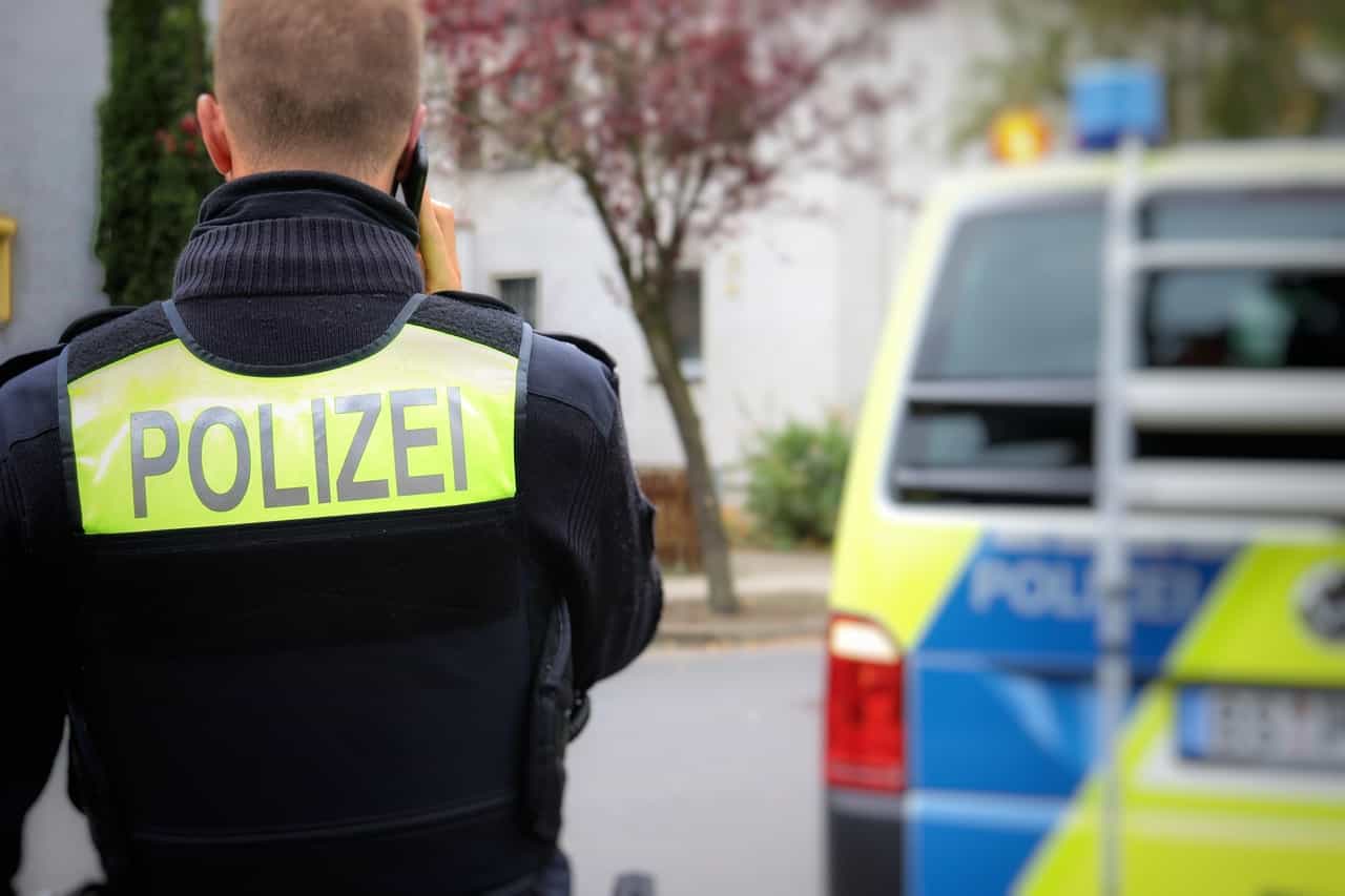 Polizeieinsatzfahrzeuge vor Gebäude